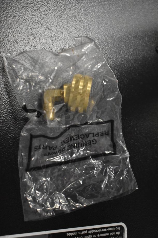 Bag with brass fitting labeled "Genuine Replacement Parts," on a black surface.