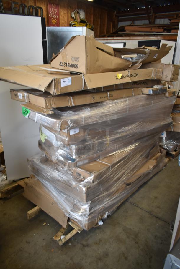 Stack of 18 brand new scratch and dent items, including John Boos wood top work table, wrapped in packaging.