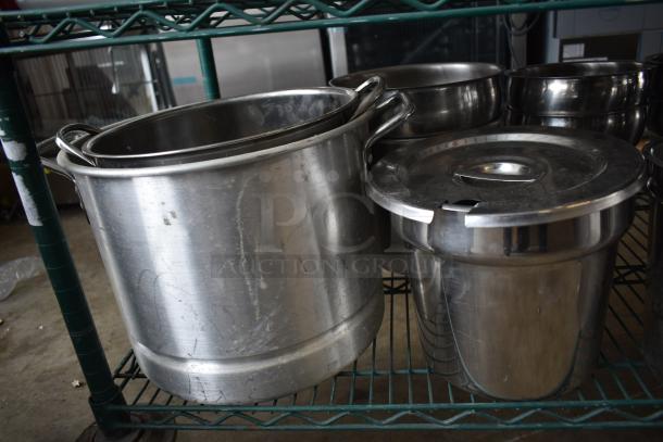 Stainless steel cylindrical bins on green metal shelving, showing minor surface scratches, in good condition.