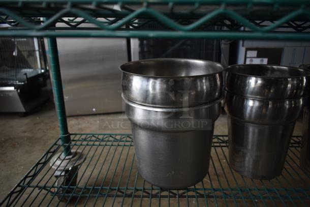Two stainless steel cylindrical bins on a green wire shelf, showing a polished finish in good condition.