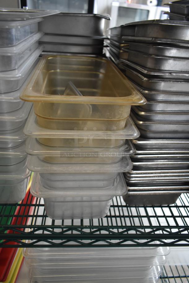 Tiered lot of stainless steel and poly drop-in bins, stacked on shelves. Various sizes and used condition.