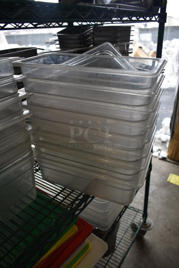 Stack of stainless steel and poly drop-in bins on a metal shelf, in good condition, various sizes, for kitchen use.
