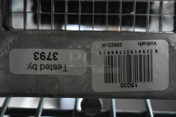 Metal vegetable cutter grid with "Tested By: 3793" label and barcode, indicating inspection and inventory details.