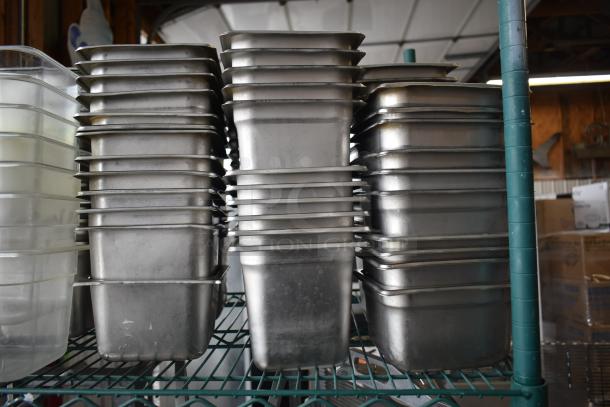 Stacked stainless steel and poly drop-in bins on a metal shelf, showing light wear. Tiered lot includes multiple similar items.