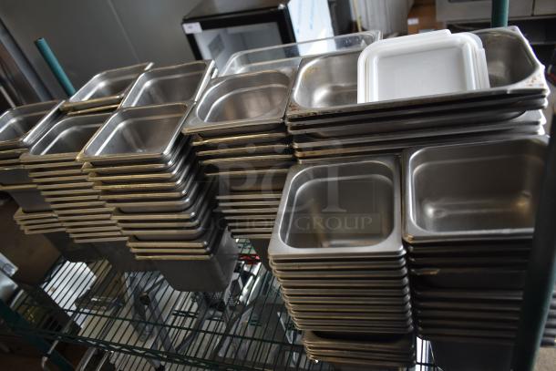 Stainless steel and poly drop-in bins stacked on a wire shelf, in good condition, suitable for commercial use.