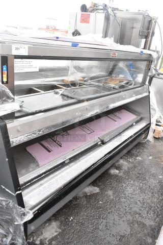 Industrial open merchandiser, floor style, metal frame, glass front, moderate wear. Signage visible, offers ample display area.