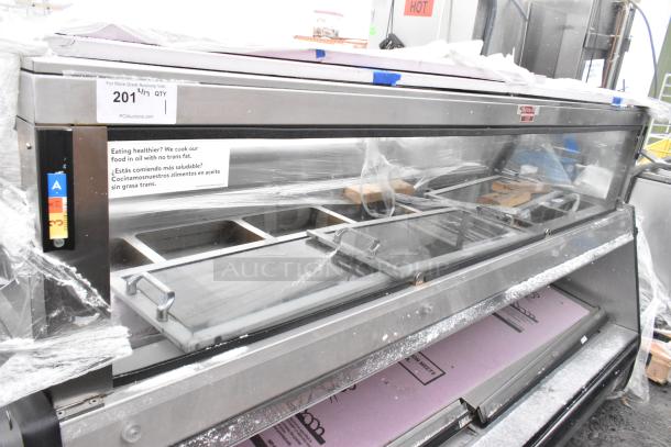 Commercial floor style open merchandiser in used condition, featuring multiple shelves and a stainless steel finish.