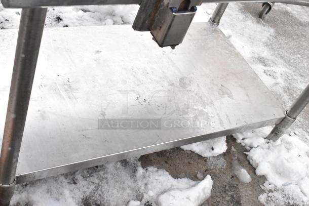 Metal table with commercial can opener and undershelf. Features sturdy metal legs and caster wheels. Used condition.