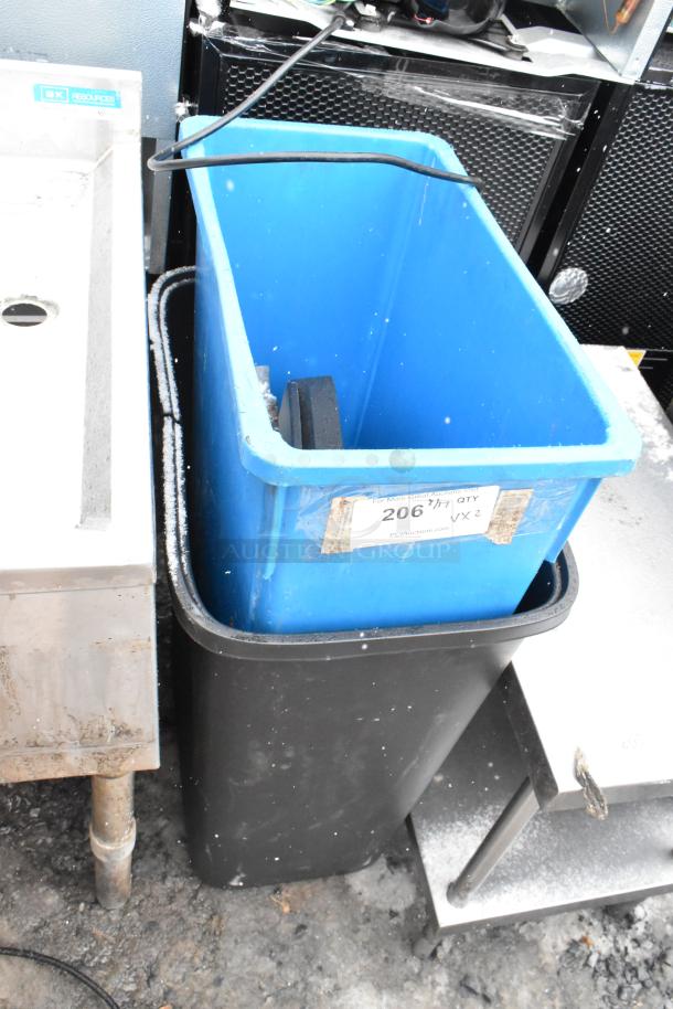 Two poly trash cans, black and blue, stacked together. Visible label with auction lot number 206.