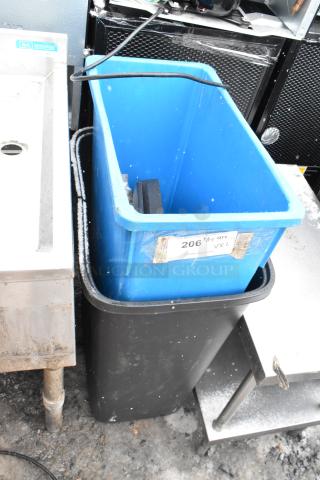 Two poly trash cans, black and blue, stacked together. Visible label with auction lot number 206.