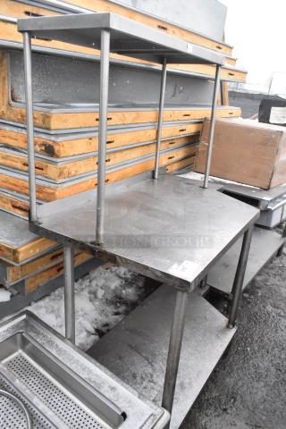 Stainless steel table with under and over shelf, used, sturdy construction, suitable for industrial use.