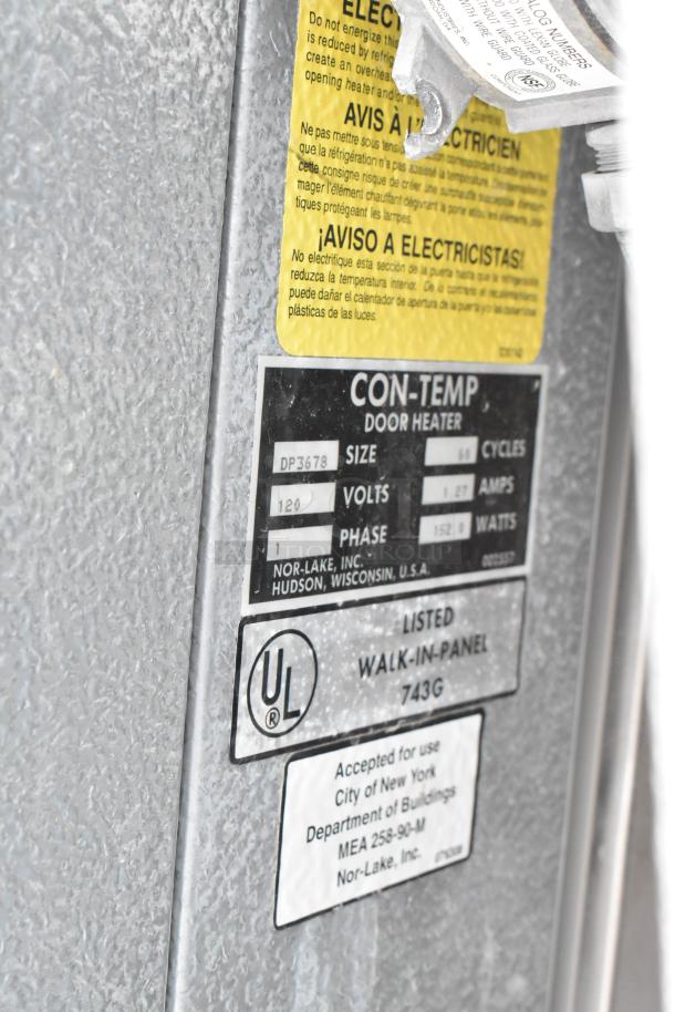 Close-up of Norlake walk-in box panel showing labels with electrical specifications, UL certification, and NYC approval.