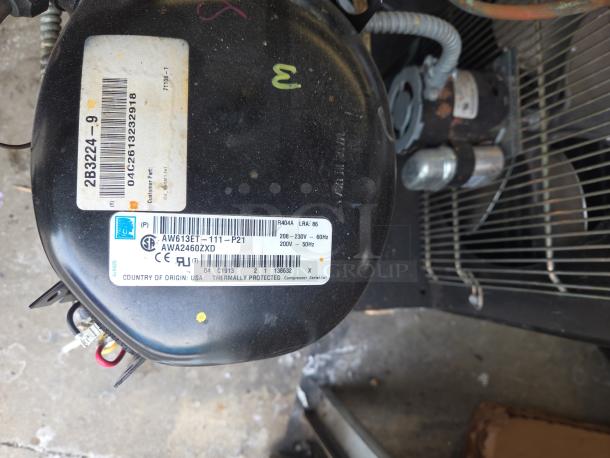 Norlake Tecumseh AW613ET-111-P21 compressor, labeled with specifications and serial number, used in walk-in cooler/freezer.