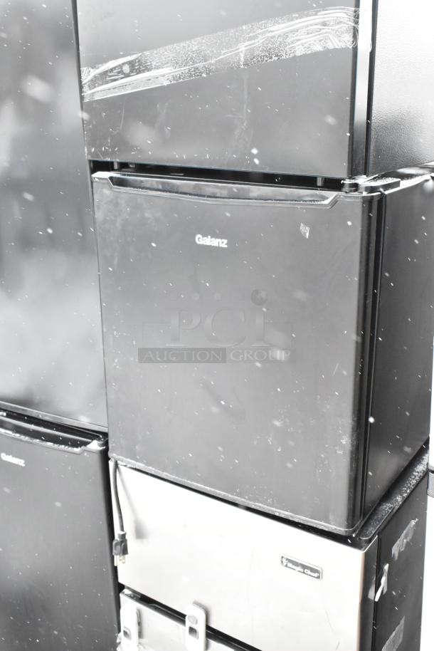 Nine mini coolers, including Galanz GLR33MBKE23 and GLR31TS1E02, 120V, 1 phase, stacked. Appears used. Multiple brands visible.