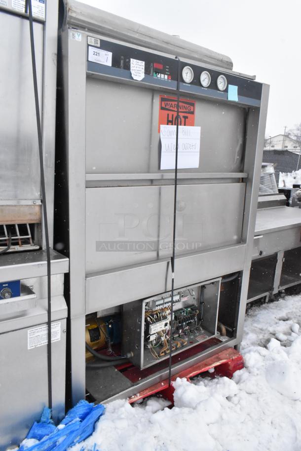 Douglas Commercial Front Load Pot and Pan Washer, stainless steel, visible "HOT" warning label, open wiring panel, snow-covered.