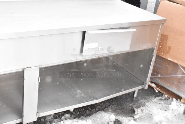 Win-holt stainless steel table, two drawers, under shelf, visible wear. Suitable for commercial kitchens.