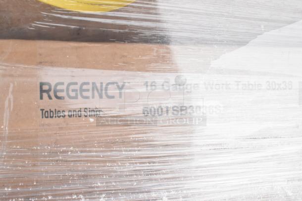Regency 16-gauge work table, model 600TSB3036, wrapped in plastic. Includes shelving and other items.