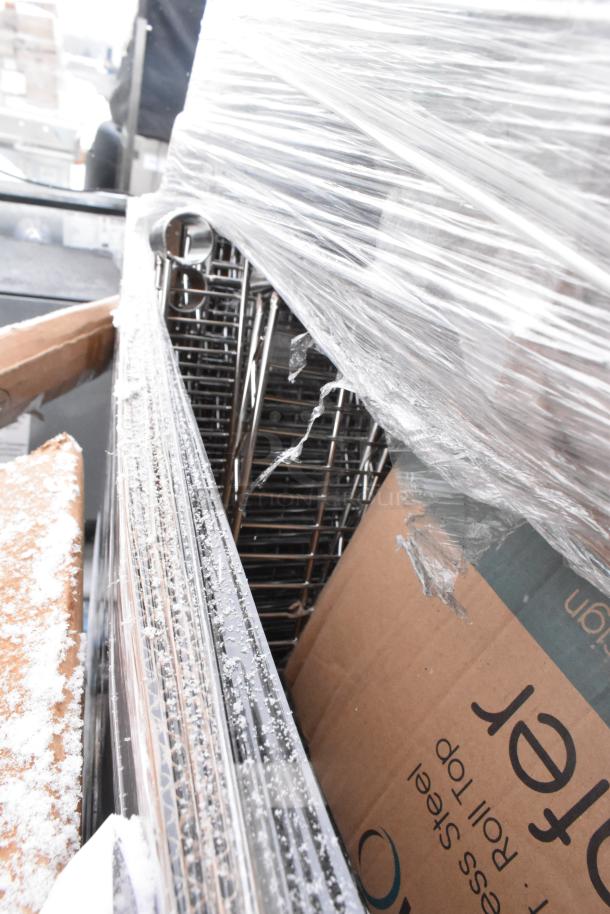 Plastic-wrapped bundle containing various items like a table and metal shelves, partially visible, with cardboard packaging.
