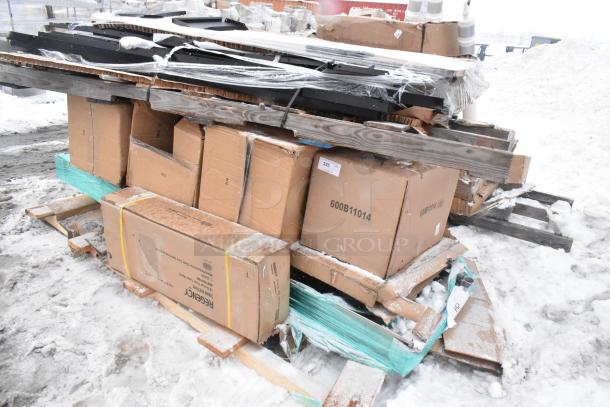 Mixed lot of 11 items on pallets, including various tables, packed in cardboard boxes with visible wear and snow.