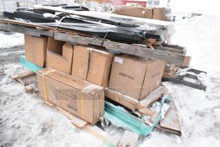 Mixed lot of 11 items on pallets, including various tables, packed in cardboard boxes with visible wear and snow.