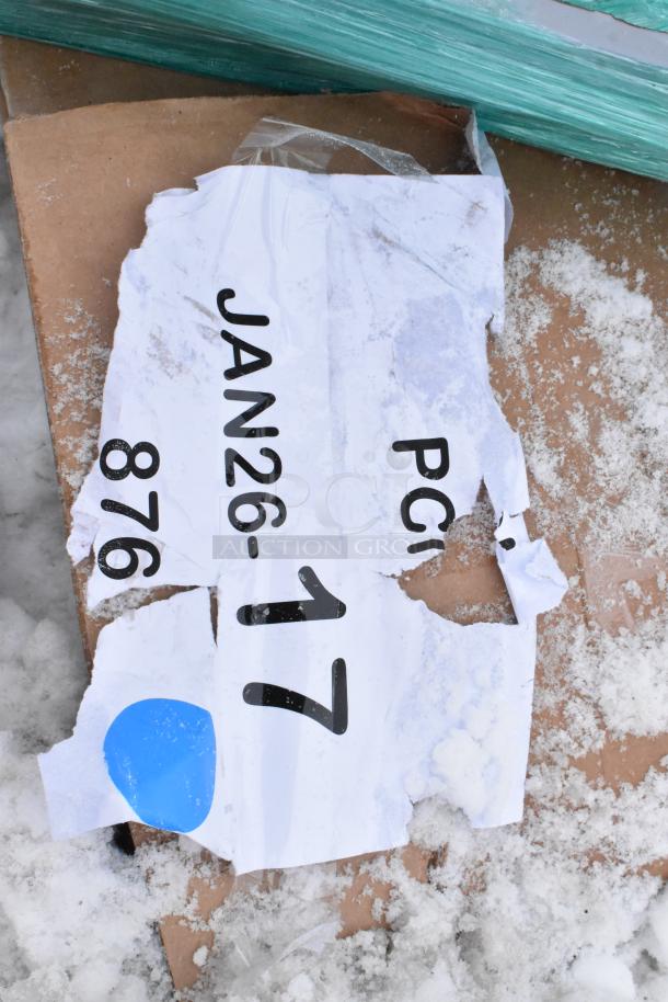 Torn shipping label with "JAN26-17" and number "876" on snow-covered cardboard. Blue dot sticker visible.