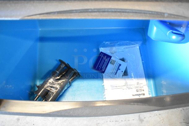 Brand new Manitowoc UYF0140A-161B ice machine interior, tags visible, 90 lb. bin capacity, half dice cubes, 115 volts.