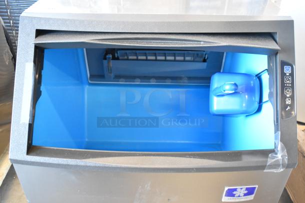 Brand new Manitowoc UYF0140A-161B ice machine with 90 lb bin, 115 volts, featuring a blue interior. Scratch and dent condition.
