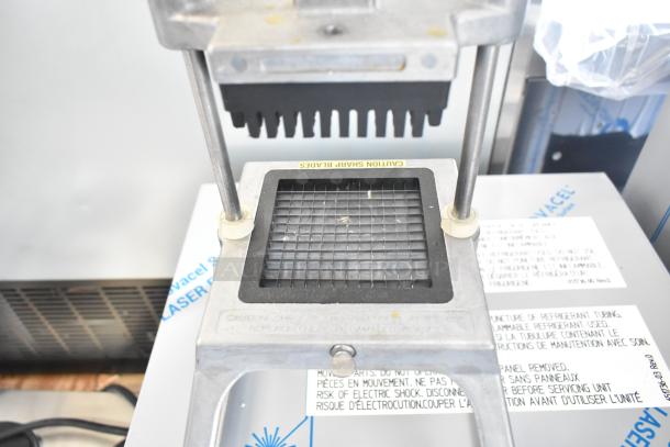 Lettuce head cutter with sharp blades and grid design, used for efficient vegetable slicing. Caution label visible.
