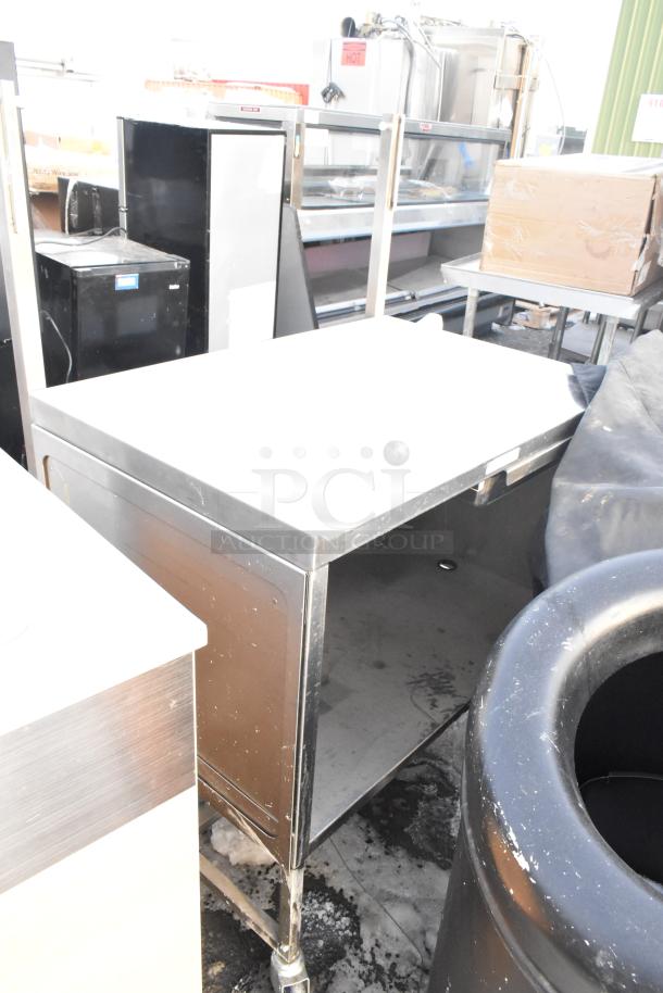 Metal cart with two shelves and an undershelf on casters. Features durable construction, visible wear, and mobility. Ideal for storage.