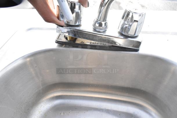 Portable sink on casters with chrome faucet, instant flow water heater, and visible model marking "E423-2A7."