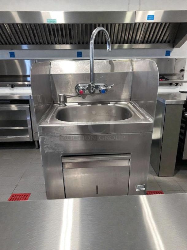 Commercial stainless steel hand wash sink with gooseneck faucet, built-in paper towel dispenser, fully operational, high-grade condition.