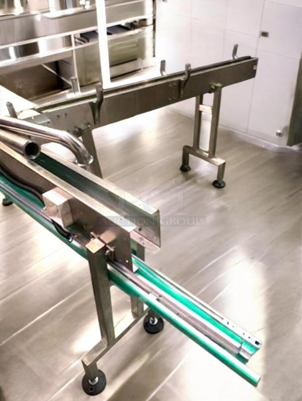Stainless steel bottle conveyor system, adjustable speed, premium condition, fully tested, part of a complete production line.