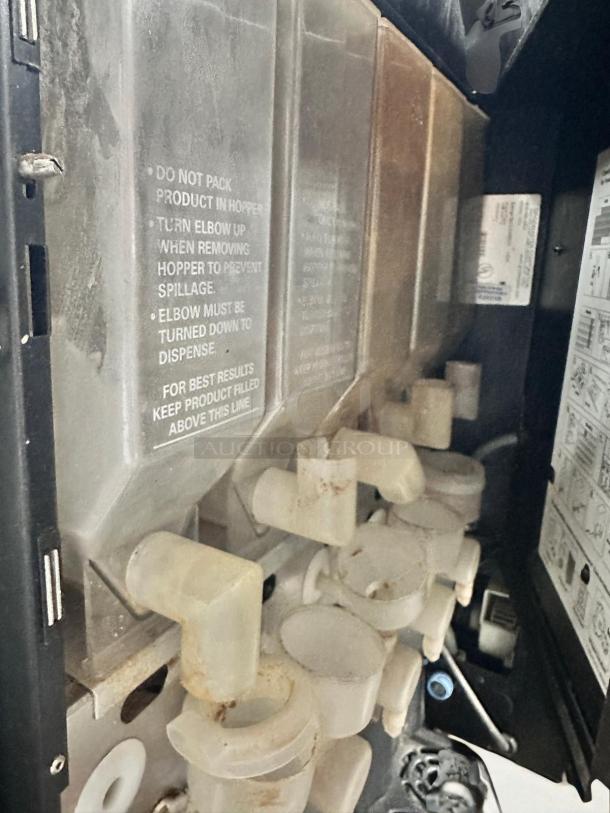 Grindmaster PIC5 beverage dispenser interior, showing hoppers and spigots. Labels indicate usage instructions.