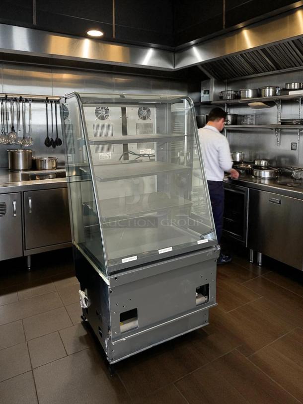 Curved glass refrigerated display case, excellent condition, 4 adjustable shelves, 115V, UL listed, tested operational.