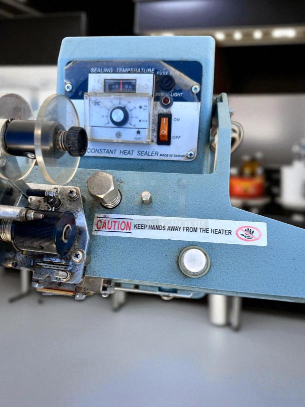 AIE ME-400CFN Constant Heat Sealer, blue, 420W, 115V, controls shown. Caution label: "Keep hands away from the heater."