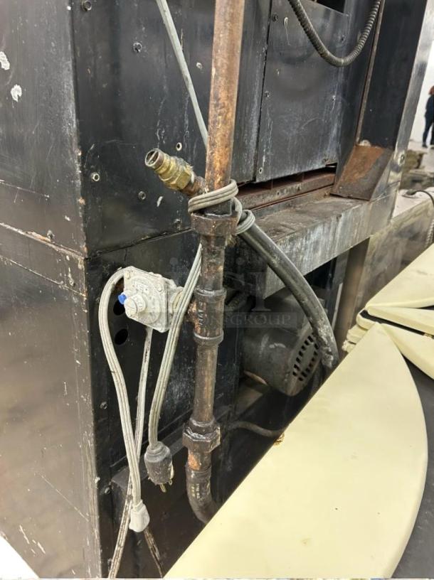 Rear view of Montague 2-115A commercial gas convection oven, showing gas connections and electrical cords. Some wear visible.