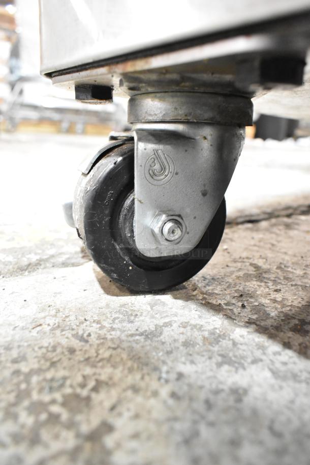 Commercial caster for Blodgett Zephaire-100-E oven, metal with rubber wheel, showing manufacturer's logo, in used condition.