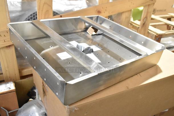 Brand new commercial drain bay strainer with minor dents, stainless steel construction, perforated surface, on a box.