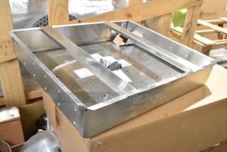 Brand new commercial drain bay strainer with minor dents, stainless steel construction, perforated surface, on a box.