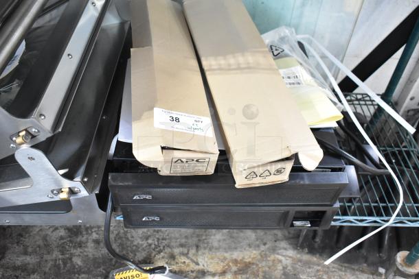 Brand new APC Uninterruptible Power Supply, scratch and dent condition, with two boxes of metal pieces. Auction tag included.