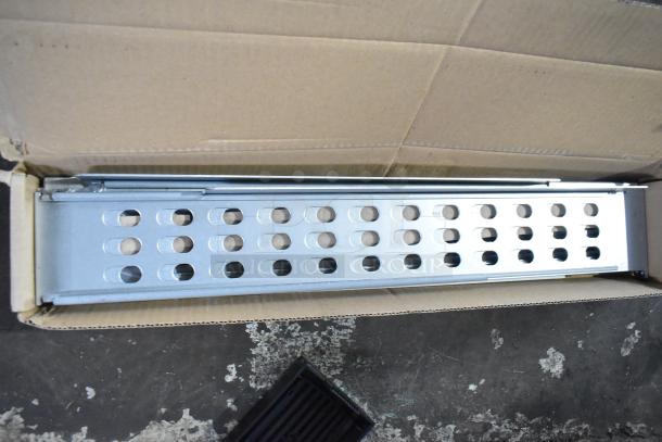 Cardboard box containing metal pieces with perforated design; part of APC Uninterruptible Power Supply set, new condition.