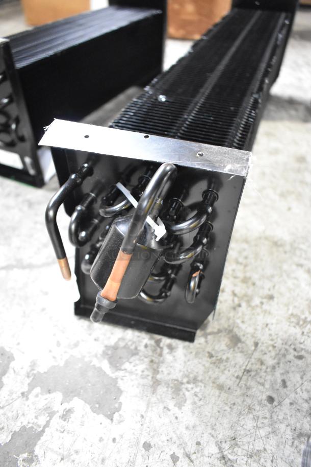 Three brand new scratch and dent evaporator coils, black metal and copper tubing, in good condition.