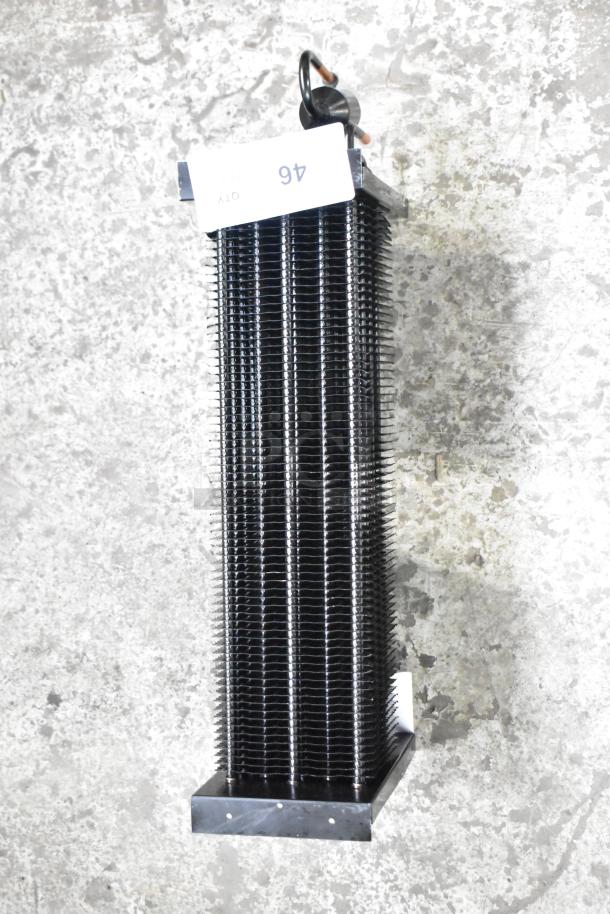 Brand new scratch and dent evaporator coil, upright with black fins, paper tag with "46 QTY" visible.