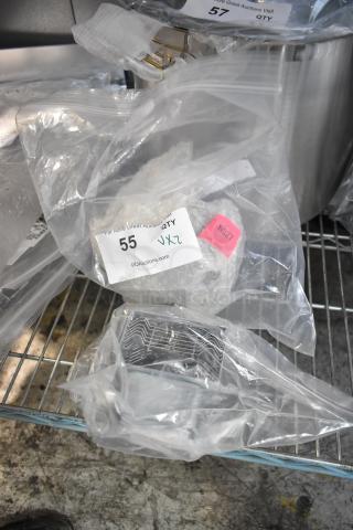 New scratch and dent items in plastic bags on metal shelf, includes magnetron. Auction label shows lot 55 from PCAuctions.com.