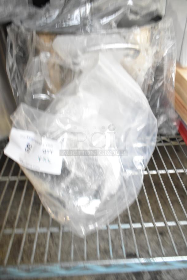 New scratch and dent fan assembly items in plastic wrap on metal shelf. Includes tags noting condition and details.