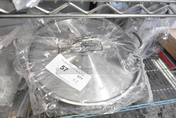 Brand new stainless steel stock pots, wrapped in plastic, minor scratches. Auction tag showing quantity of two.