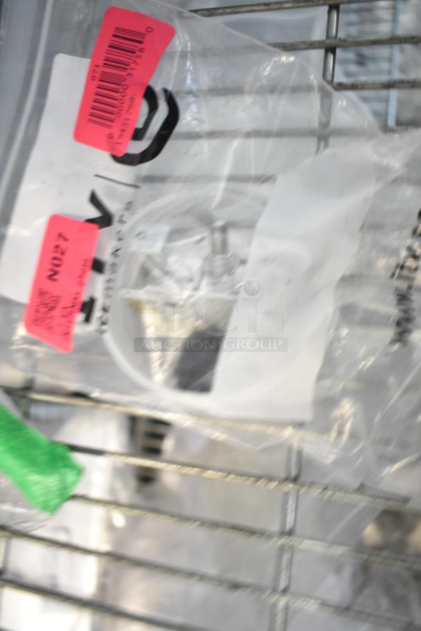 Ten brand new scratch and dent items in a clear plastic bag, with visible red tags indicating item codes.