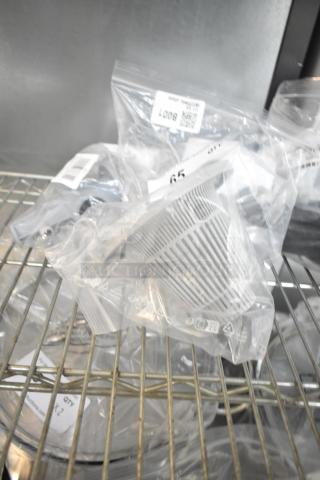 Brand new scratch and dent items including basket bushing, lower spray arm support, in sealed bags with labels.