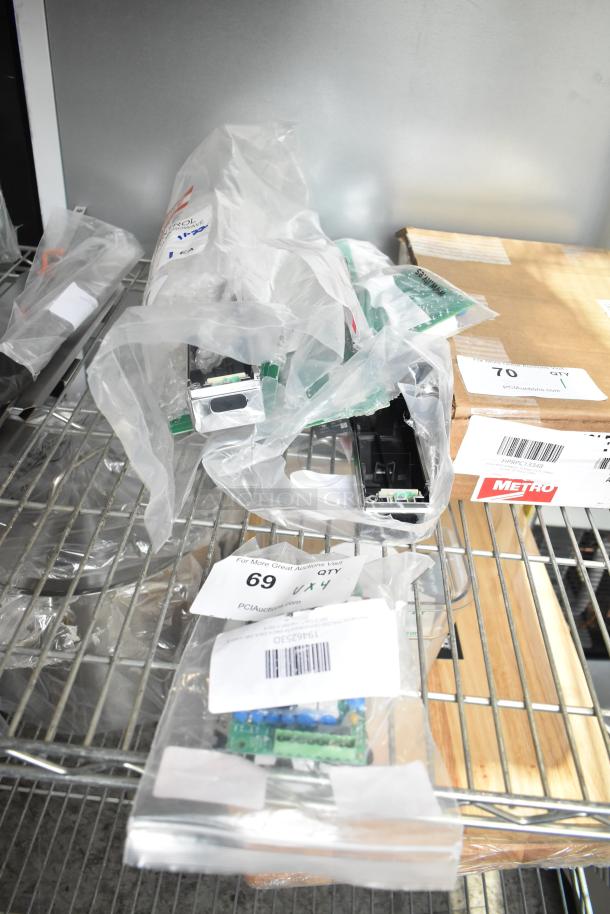 Four brand new control boards, scratch and dent, in clear plastic bags with visible labels on metal shelving.