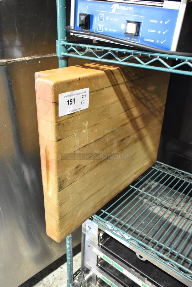 2 butcher block wooden cutting boards on metal shelf, slightly worn. Label indicates quantity of 2.